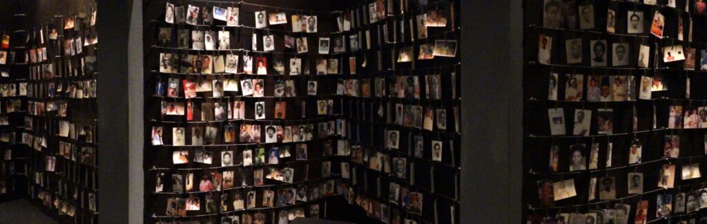Display showing photographs and names of victims at the Kigali Genocide Memorial in Rwanda educational tours
